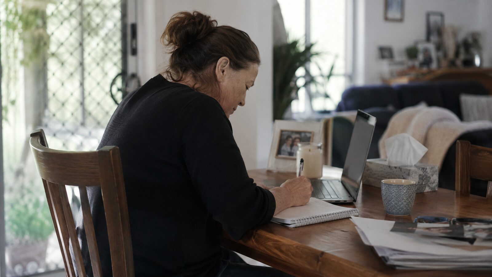 Arranging a funeral yourself: a woman organising funeral admin at home