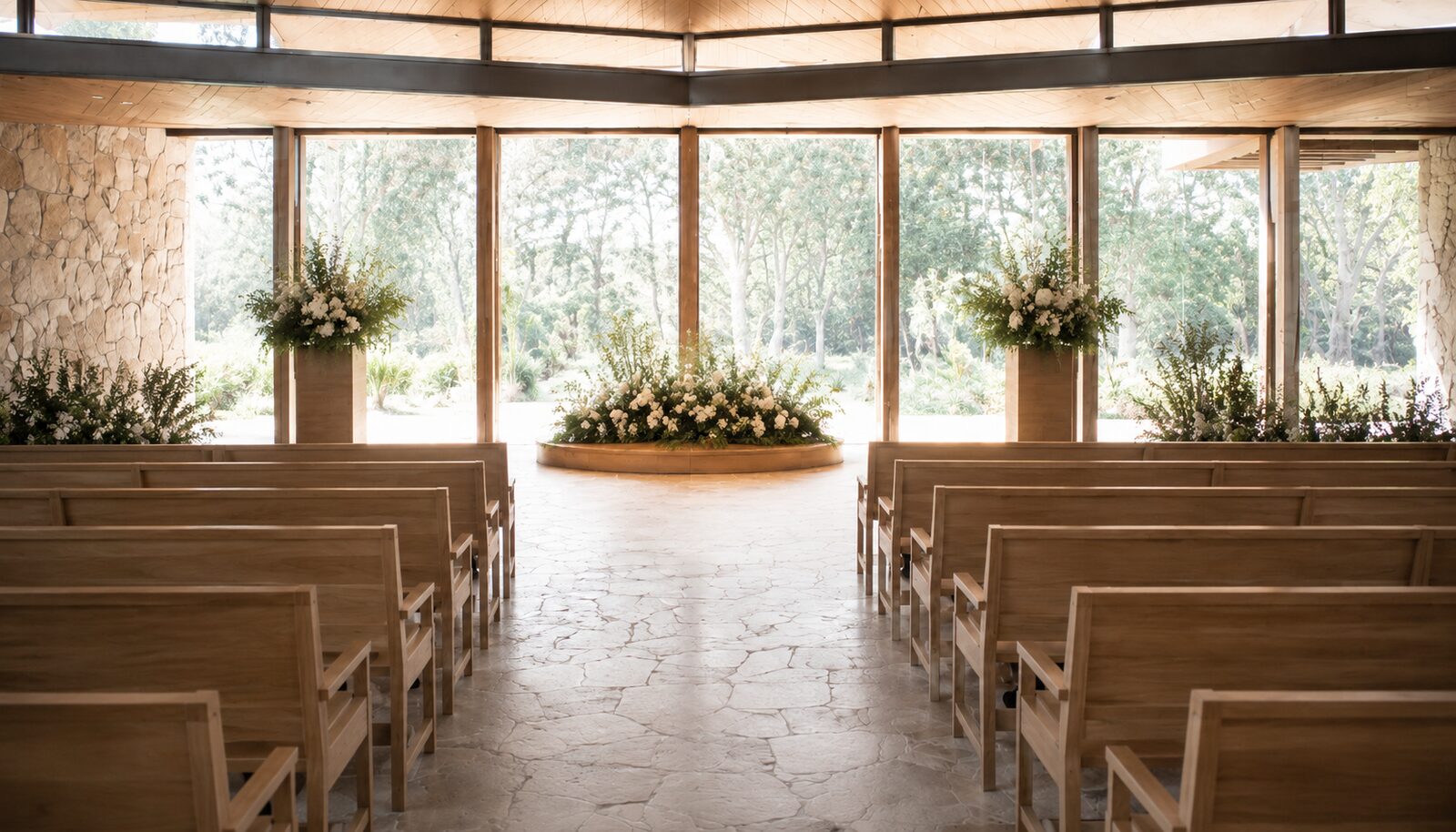 A light-filled modern chapel with timber pews and native flowers