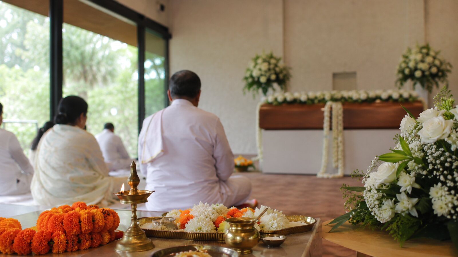 Hindu funerals in Australia: mourners in white with marigold garlands at a service