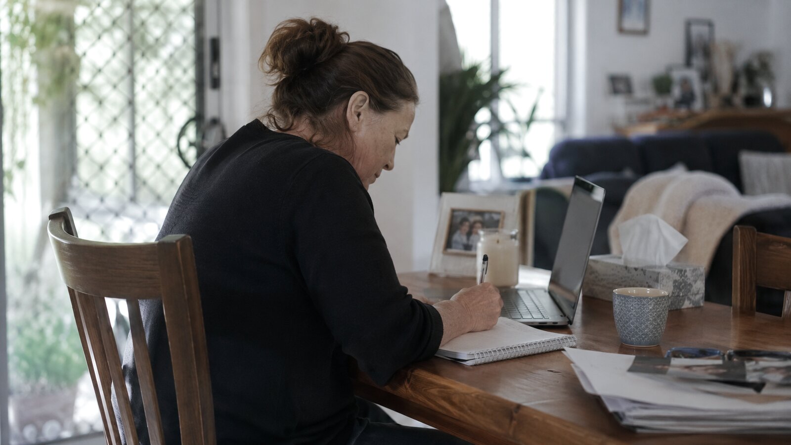 A family planning a funeral with paperwork at a table at home