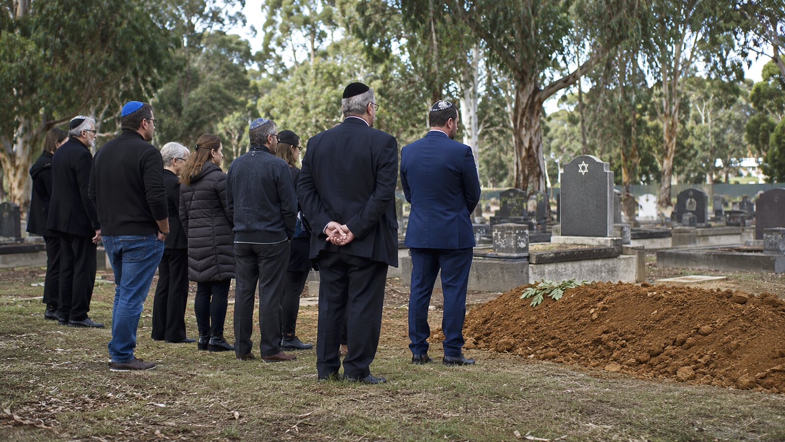 Jewish funerals in Australia: mourners in kippot at a graveside burial