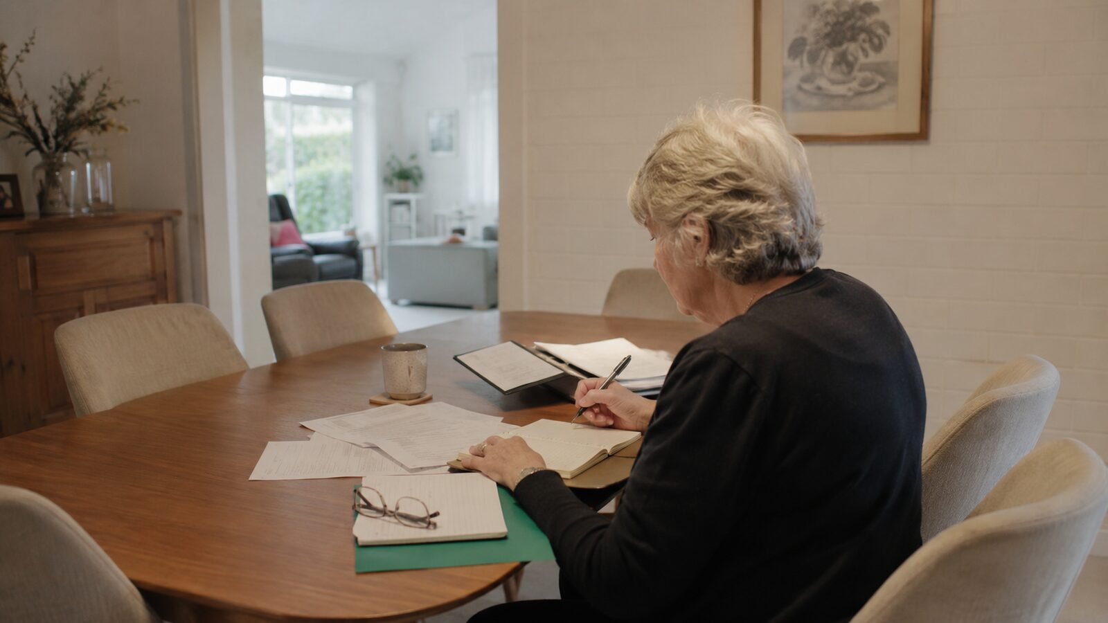 An executor working through estate paperwork and forms at a table at home